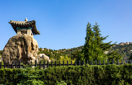 Garden with stone chinese temple and blue sky in the parkの写真素材