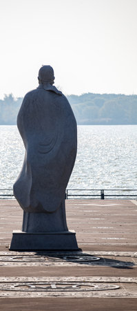 Sculpture of a man on a wooden pier on a lakeの写真素材