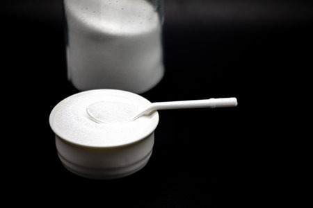 White powder in a spoon on a black background. Close up.の写真素材