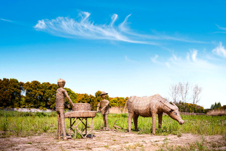 Wooden sculpture of a man and a woman in the field.の写真素材