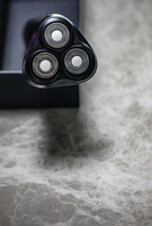 Close up of electric shaver on gray marble background with copy spaceの写真素材