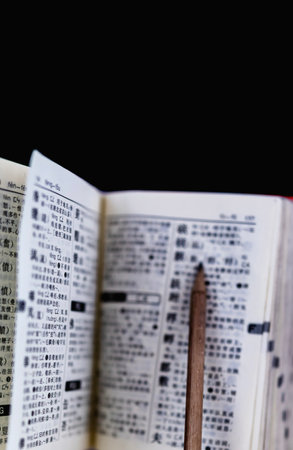 Book and pencil on a black background. Selective focus.の写真素材