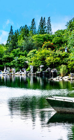 Japanese garden with lake and white boat on water in summer, Thailand.の写真素材