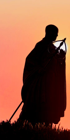 Silhouette of a monk against the setting sunの写真素材