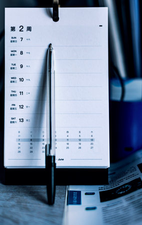 Close up of a calendar with pen and stationery on a deskの写真素材