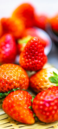 Strawberry in a bowl on a wooden table, selective focusの写真素材