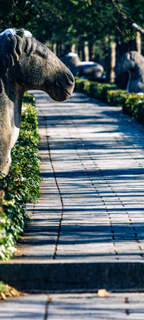 Stone sculpture of a dog on a walkway in the park.の写真素材