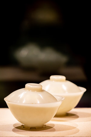 Chinese porcelain tea set on a wooden table with black backgroundの写真素材