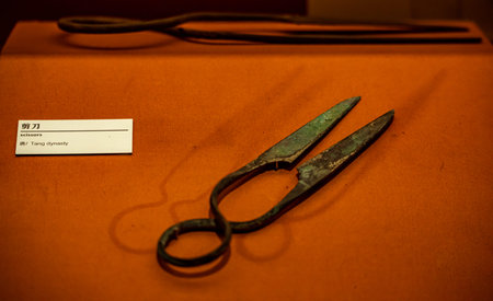 Close up of old scissors on an orange background in a museum.