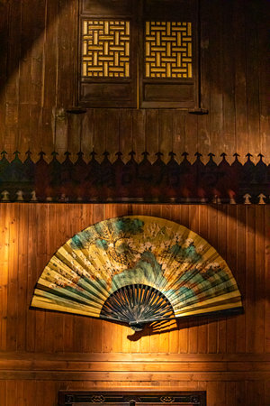 Wooden japanese hand fan on the wall of the templeの写真素材