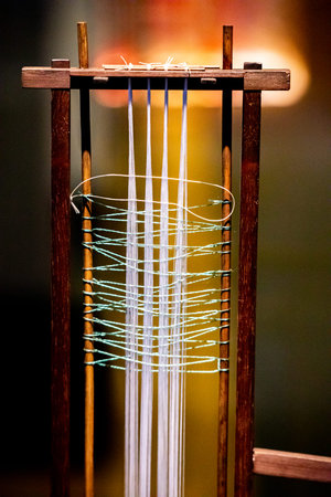 Weaving thread in a wooden loom, closeup of photo