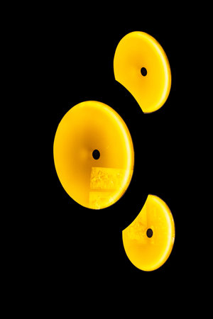 Three yellow objects isolated on black background.