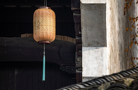 Traditional Chinese lamp hanging on the wall of a house in the countrysideの写真素材