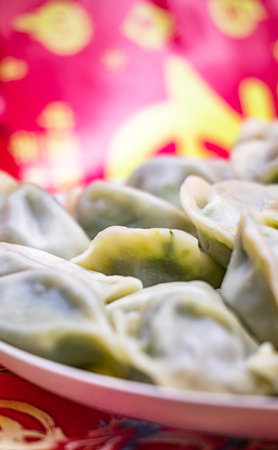 Chinese steamed dumplings in a red plateの写真素材