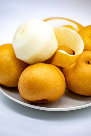 Chinese pear fruit on a plate on a white background. Close-up.の写真素材