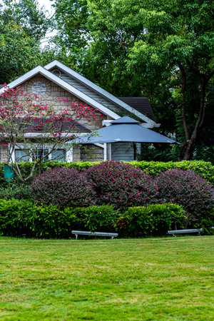 House in the garden with green grass and flower background, Thailand.