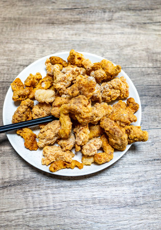 Fried pork rinds on plate with chopsticks on wooden backgroundの写真素材