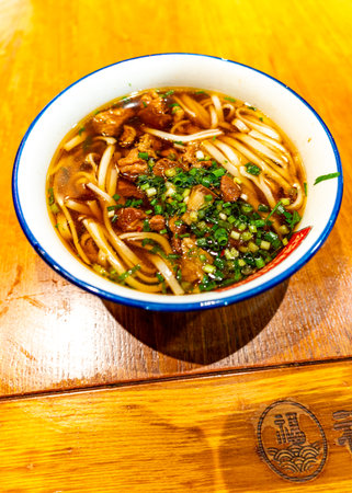 Japanese noodle soup with pork in a bowl on a wooden tableの写真素材