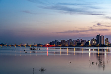 Cityscape at night with reflection in the water, Suzhou, China.