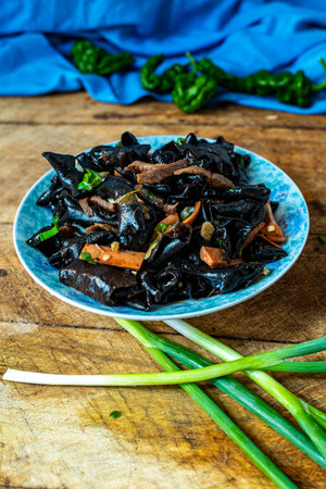 Chinese food, stir-fried black squid ink with herbs and spicesの写真素材