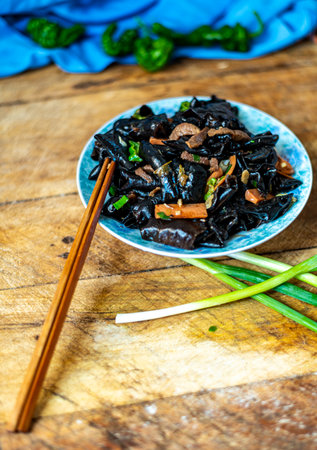Stir-fried black squid ink on a plate with chopsticksの写真素材