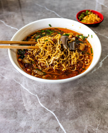 Chinese noodle soup with vegetables, herbs and spices in a bowl.