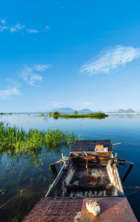 Fishing boat on the lake in the morning with blue sky backgroundの写真素材