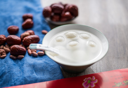 Red date fruit and coconut milk with red envelope on wooden table.