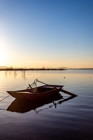 Fishing boat in the lake at sunset. Beautiful summer landscape.