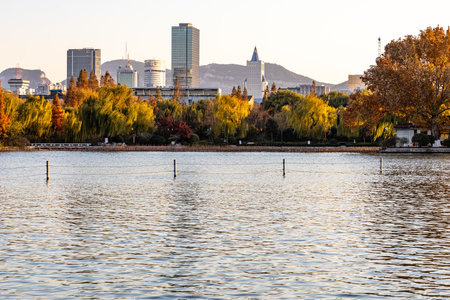 Beautiful autumn landscape in the park with lake and cityscape backgroundの写真素材