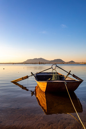Fishing boat on the shore of the lake in the evening.
