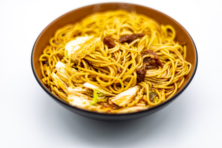 Noodles with meat and vegetables in a bowl on white backgroundの写真素材