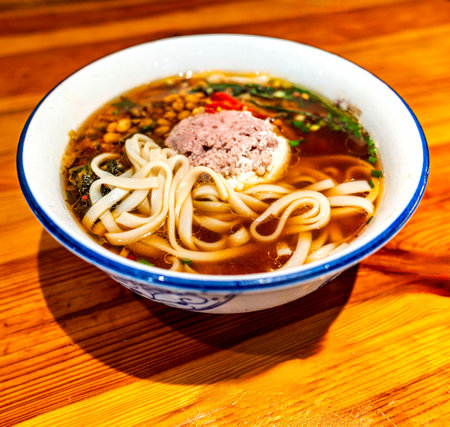 Bowl of Japanese miso ramen noodle soup on wooden tableの写真素材