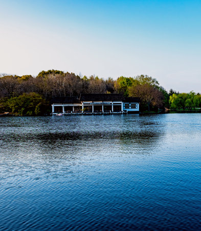 Pavilion on the lake with trees in the background and blue skyの写真素材