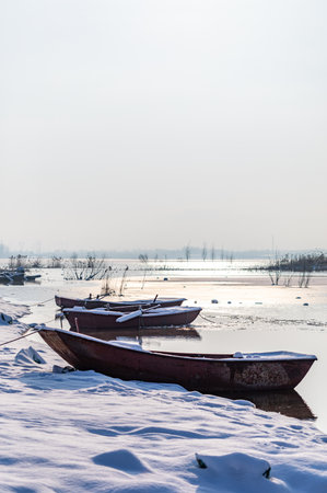 Fishing boats on the frozen lake in winter. Winter landscape.の写真素材