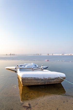 Fishing boat on the frozen lake in winter, closeup of photoの写真素材