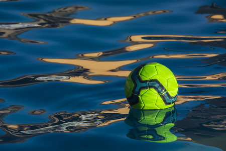 The yellow soccer ball floating on the swimming poolの写真素材