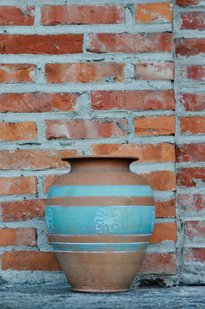 Old pitcher pot on a brick wall backgroundの写真素材