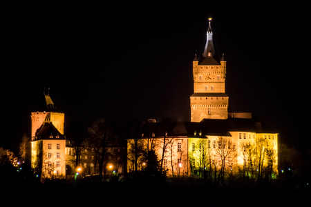 Old german castle tower clock palace at nightの写真素材