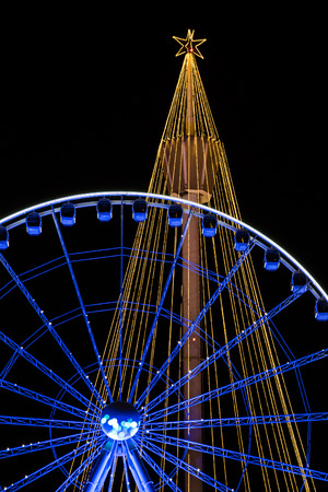 Orange and blue christmas lighting installed on tower and big wheelの写真素材