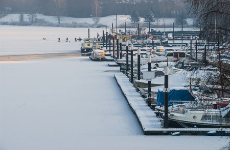 Frozen up harbor port icebound boats ships winter snowの写真素材