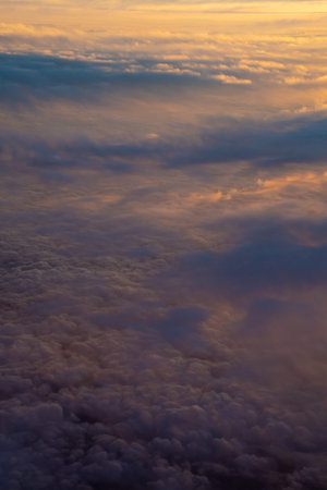 Cloud cover illuminated by sunset half orange and half in the earth shadow
