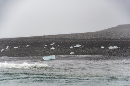 Diamond beach black sand crystal clear piece of ice washed up on Atlantic shore
