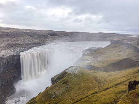 Dettifoss waterfall in Iceland long exposure of water falling over the edge creating big clouds of...