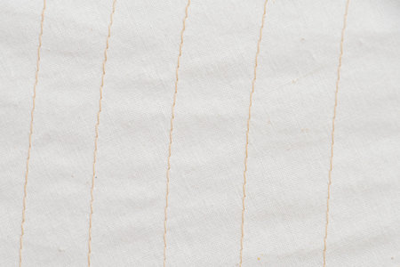 Sailcloth in white texture of woven fabric with beige stitching stripes