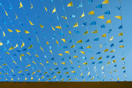 Colorful flags on the roof of a building against the blue skyの写真素材
