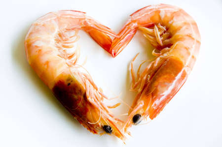 Two prawns placed on a white plate to form the shape of a heartの写真素材