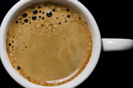 Closeup of a small white cup of freshly brewed coffee の写真素材