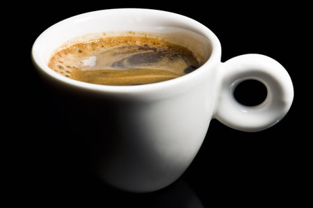 Closeup of a small white cup of freshly brewed coffee 