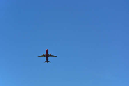 Flying airplane in the blue cloudless skyの写真素材